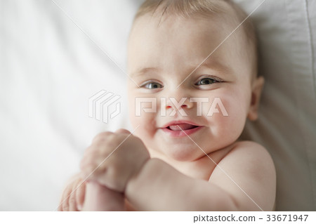 Cute happy 7 month baby girl in diaper lying and 33671947