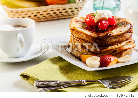 Pancakes with chocolate sauce fruit and coffee 33672412