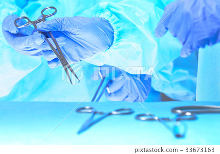 Close-up of of surgeons hands at work in operating 33673163