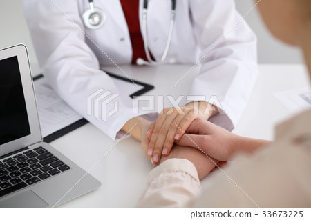 Hand of doctor reassuring her female patient Hand of doctor reassuring her female patient 33673225