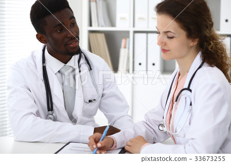 Happy smiling african american male doctor talking Happy smiling african american male doctor talking 33673255
