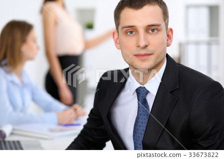 Portrait of a young business man against a grou Portrait of a young business man against a grou 33673822