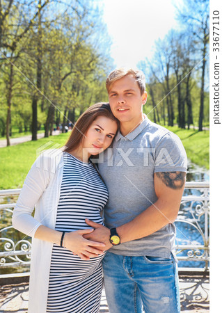 Handsome man and his beautiful pregnant wife are 33677110
