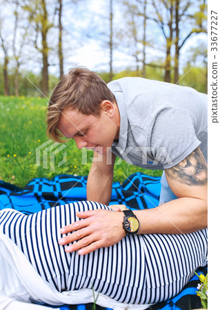 man touching the belly of a pregnant woman 33677227