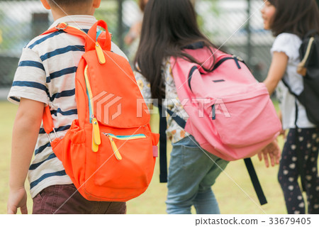Three pupils of primary school go hand in hand. 33679405
