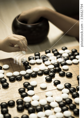 Chinese Go or Weiqi board game - black and stone Chinese Go or Weiqi board game - black and stone 33682794