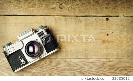 Old retro camera on wooden planks boards. Old retro camera on wooden planks boards. 33685011