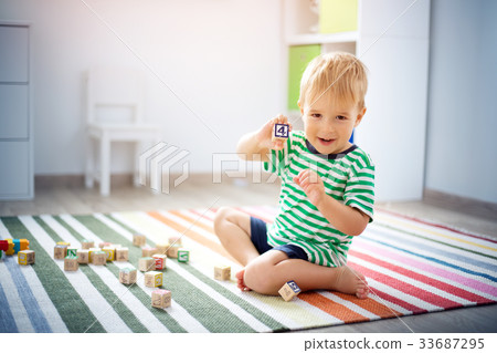 two years old child sitting on the floor with 33687295