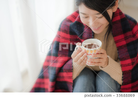Woman wearing a knitwear drinking cocoa 33688869