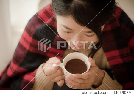 Woman wearing a knitwear drinking cocoa Woman wearing a knitwear drinking cocoa 33689079