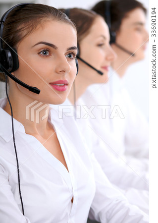Call center. Focus on beautiful woman in headset Call center. Focus on beautiful woman in headset 33690194