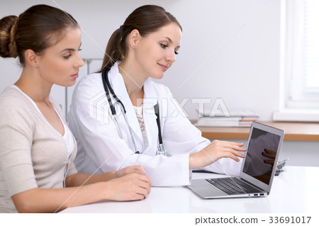 Doctor and  patient  sitting at the desk. Physici 33691017