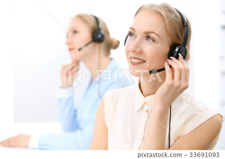 Call center. Focus on beautiful blonde woman in 33691093