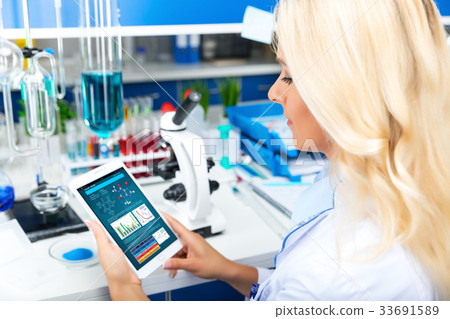 Woman scientist using tablet computer in the lab Woman scientist using tablet computer in the lab 33691589