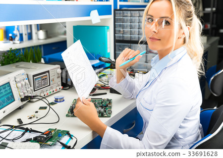 Female electronic engineer checking electronics 33691628