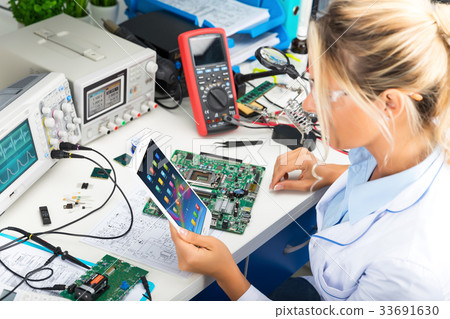 Female electronic engineer using tablet computer Female electronic engineer using tablet computer 33691630