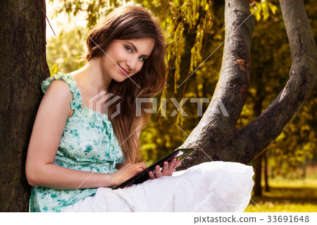 Woman reading e-book in the park 33691648