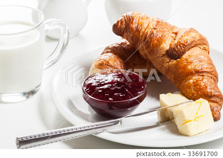 Croissants with butter and a glass of milk Croissants with butter and a glass of milk 33691700
