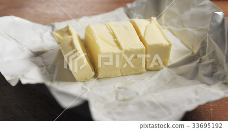 slicing butter with knife on kitchen closeup slicing butter with knife on kitchen closeup 33695192