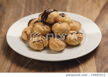 profiteroles with fine dark chocolate on plate 33695413