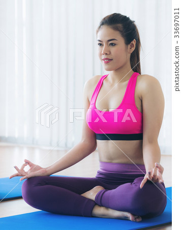 Woman practicing yoga pose in gym 33697011