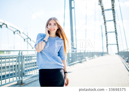 Beautiful happy young businesswoman using cell Beautiful happy young businesswoman using cell 33698375