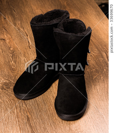 Top view of winter boots standing on wooden Top view of winter boots standing on wooden 33699670