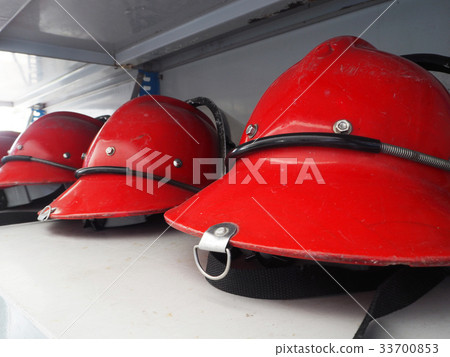Red fireman helmet prepared on shelf. Red fireman helmet prepared on shelf. 33700853