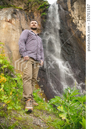 A bearded hipster in a plaid shirt stands against A bearded hipster in a plaid shirt stands against 33701387