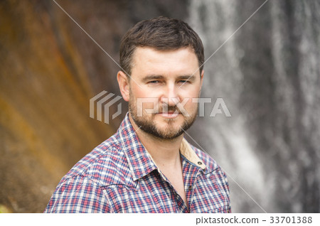 Close-up portrait of a bearded hipster against a Close-up portrait of a bearded hipster against a 33701388