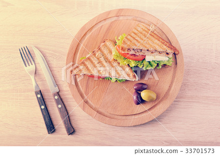 two triangular sandwiches and olives  33701573