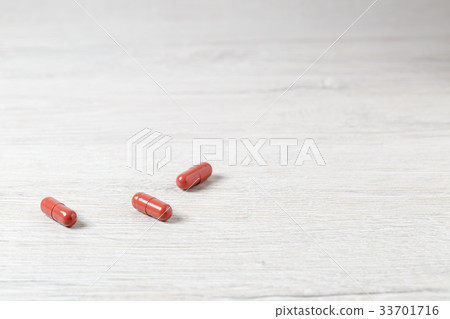 Three brown medicine capsules Three brown medicine capsules 33701716