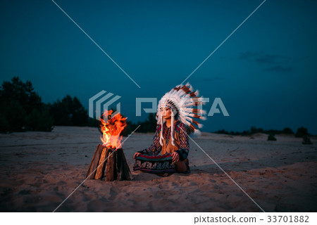 Young American Indian woman against fire Young American Indian woman against fire 33701882