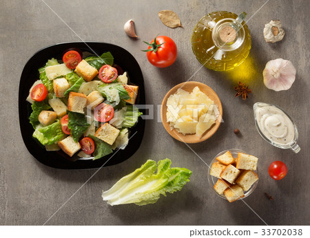 caesar salad and ingredients at table 33702038