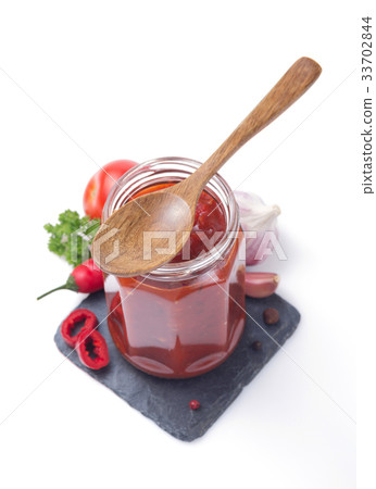 tomato sauce in glass jar on white 33702844
