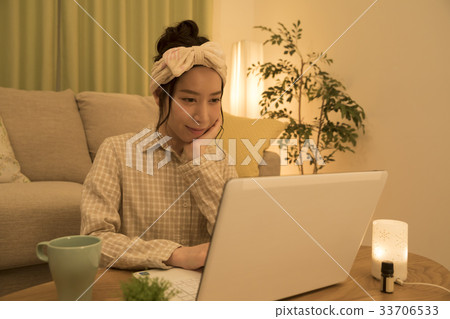 檢查計算機的婦女,當採取芳香在晚上時 檢查計算機的婦女,當採取芳香在晚上時 33706533