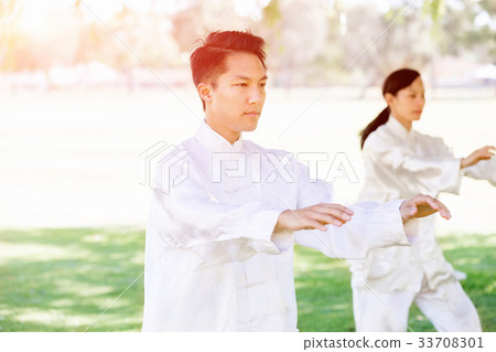 People practicing thai chi in park People practicing thai chi in park 33708301