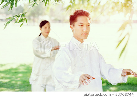 People practicing thai chi in park People practicing thai chi in park 33708744