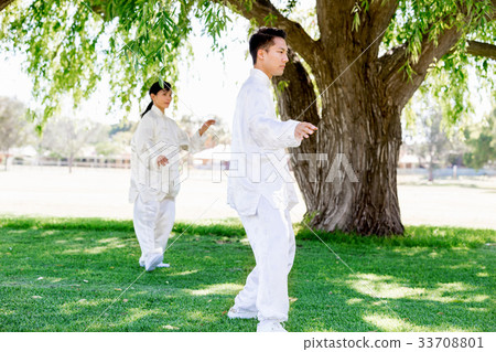People practicing thai chi in park People practicing thai chi in park 33708801