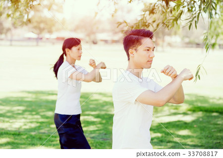 People practicing thai chi in park People practicing thai chi in park 33708817