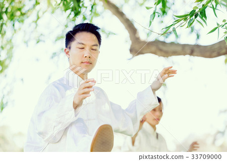 Handsome man practicing thai chi Handsome man practicing thai chi 33709000