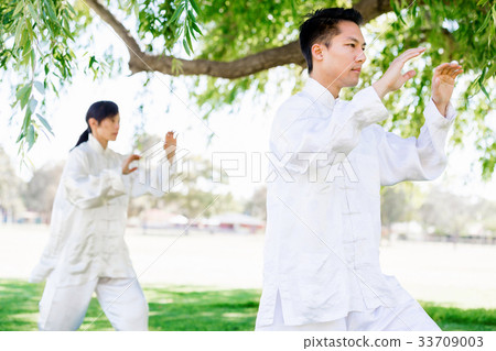 People practicing thai chi in park People practicing thai chi in park 33709003