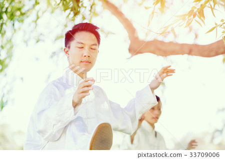 Handsome man practicing thai chi Handsome man practicing thai chi 33709006