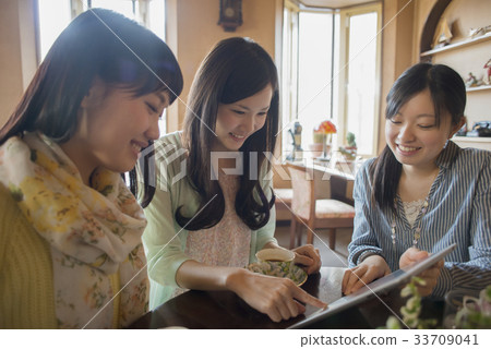 Three women looking at a tablet Three women looking at a tablet 33709041