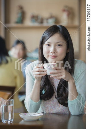 Smiling woman holding a tea cup 33709127