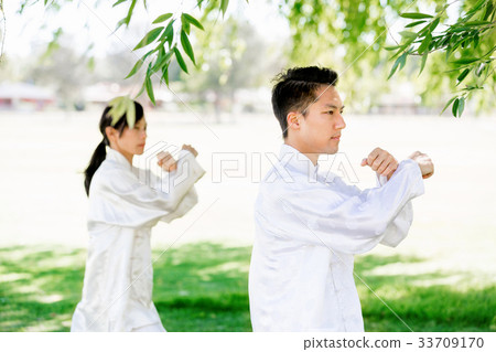 People practicing thai chi in park People practicing thai chi in park 33709170