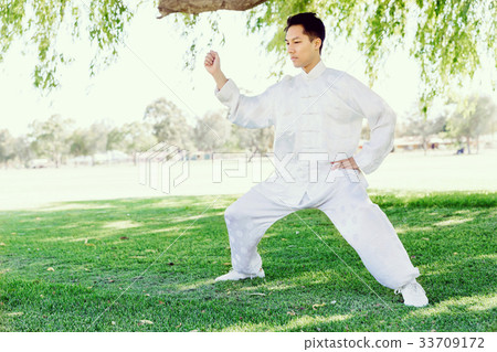 Handsome man practicing thai chi Handsome man practicing thai chi 33709172