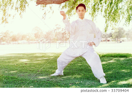 Handsome man practicing thai chi Handsome man practicing thai chi 33709404