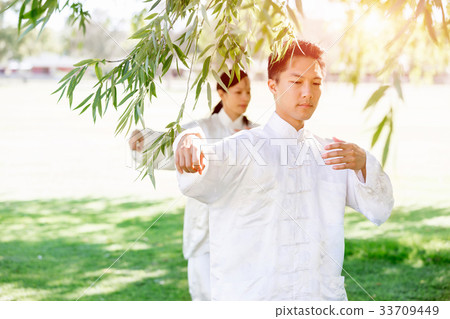 People practicing thai chi in park 33709449