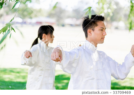 People practicing thai chi in park 33709469